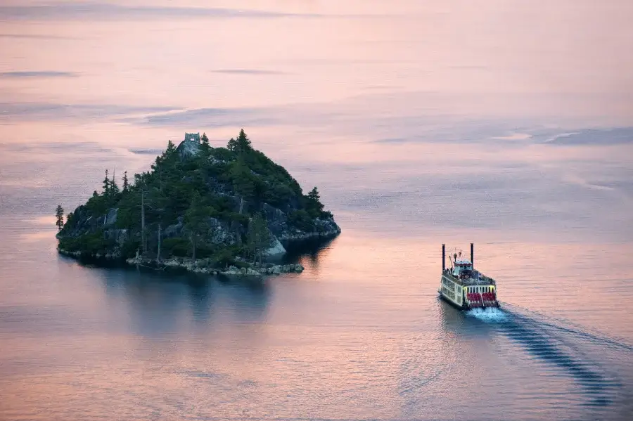 Looking down at Emerald Bay with pink reflection of the sunset and the M.S. Dixie paddling by Fannette Island